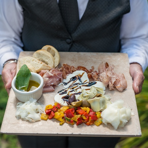 server with charcuterie board at an outdoor event at Brookside Country Club